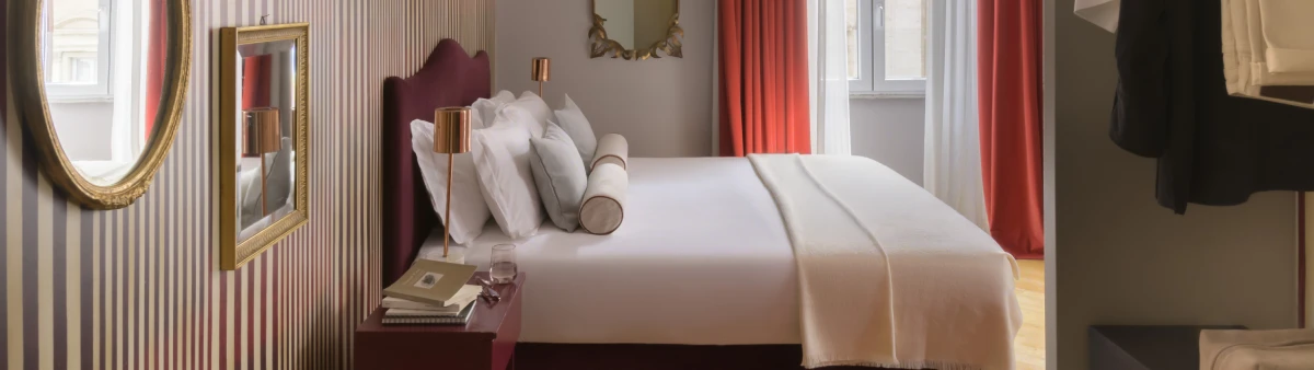 Double bed in Junior Suite in Rome Monti district with burgundy headboard, striped wallpaper and design bedside tables - Salotto Monti, BZAR hotels in Rome